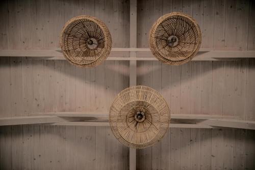 four straw umbrellas hanging on a wall at Villa Cossoro Ena in Zakynthos in Xirokástellon