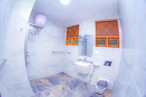 a white bathroom with a sink and a toilet at Ama Airport Hotels in Seeduwa
