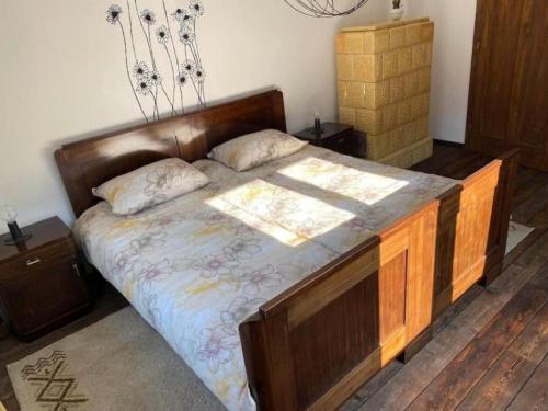 a bedroom with a large bed with a wooden headboard at doLodge homestead in the Kolpa River canyon in Stari Trg ob Kolpi