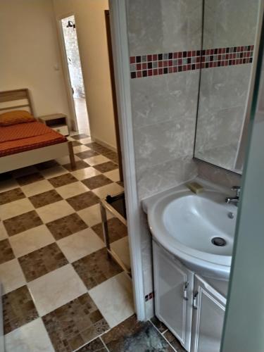 a bathroom with a sink and a tiled floor at 15 minutes de Fort de France in Saint-Joseph