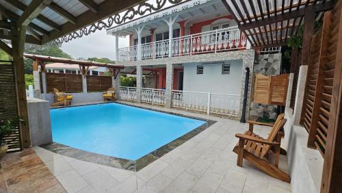 a swimming pool on a patio with a house at 15 minutes de Fort de France in Saint-Joseph