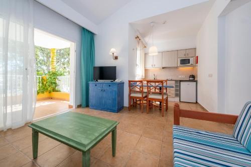 a living room with a table and a kitchen at Comitas Isla del Aire in Punta Prima