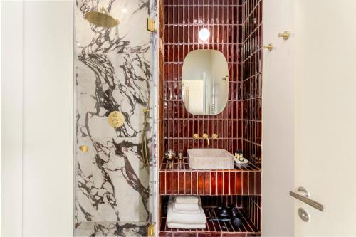 une salle de bain avec un lavabo et un miroir dans l'établissement Habitat Parisien - Grands Boulevards Montorgueil, à Paris