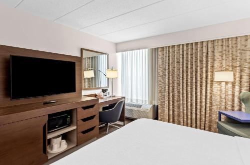 a hotel room with a bed and a television at Hampton Inn Chicago-Naperville in Naperville