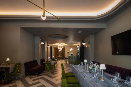 a dining room with long tables and green chairs at Amsterdam Plaza Hotel & SPA in Palanga