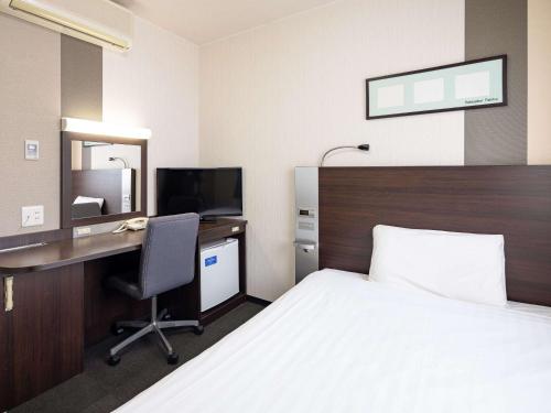 a hotel room with a bed and a desk at Comfort Hotel Himeji in Himeji
