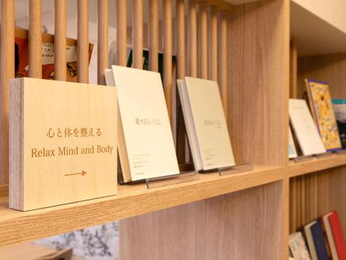 a row of books sitting on a shelf at Comfort Hotel Himeji in Himeji