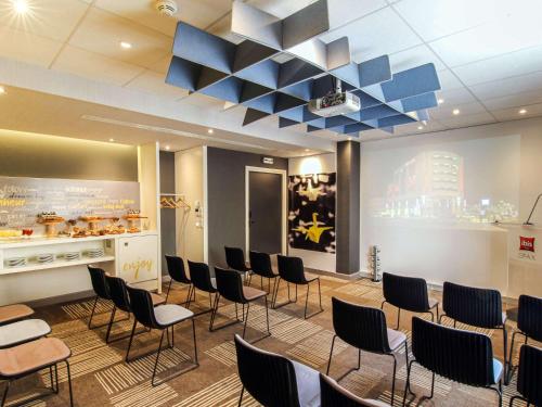 a waiting room with black chairs and blue ceilings at Ibis Sfax in Sfax