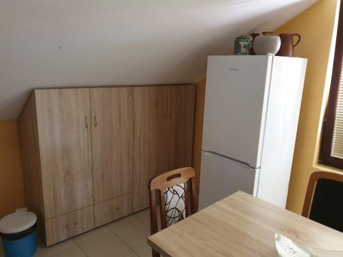 a kitchen with a white refrigerator and a wooden cabinet at Apartmani Mile in Soko Banja