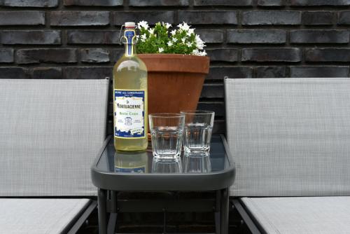 une bouteille de vin posée sur une table avec deux verres dans l'établissement B&B Nr 3, à Middelbourg