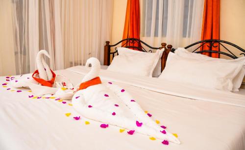 two swans are sitting on top of a bed at Dovenest Lodge in Naivasha