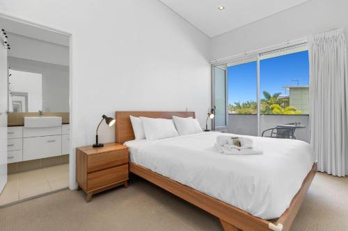 ein Schlafzimmer mit einem großen Bett und einem großen Fenster in der Unterkunft Bula Holiday Villa in Casuarina