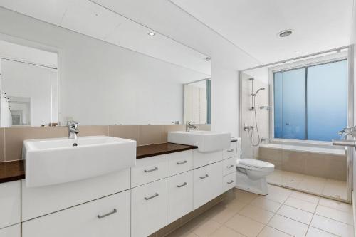 ein weißes Badezimmer mit Waschbecken und Toilette in der Unterkunft Bula Holiday Villa in Casuarina