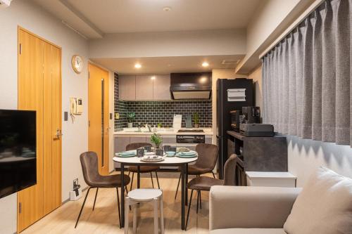 a living room and kitchen with a table and chairs at ACROSS Akihabara in Tokyo
