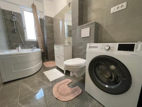 a bathroom with a washing machine and a toilet at 2 Rooms Apartament Q Residence in Iaşi