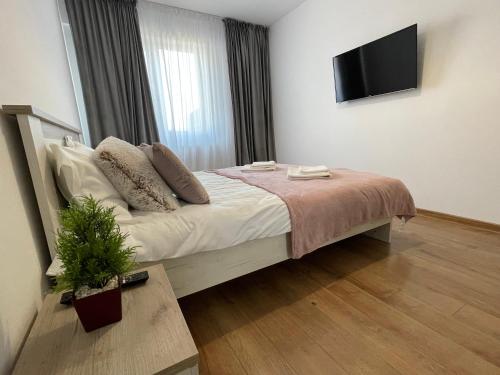 a bedroom with a bed with a tv on the wall at 2 Rooms Apartament Q Residence in Iaşi