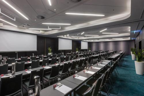 a conference room with rows of tables and chairs at PARKROYAL Darling Harbour, Sydney in Sydney