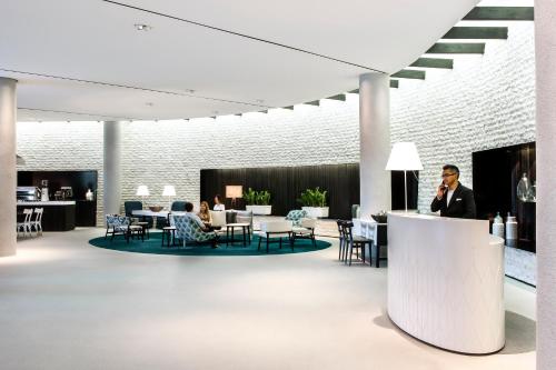 a man talking on a cell phone in a lobby at PARKROYAL Darling Harbour, Sydney in Sydney