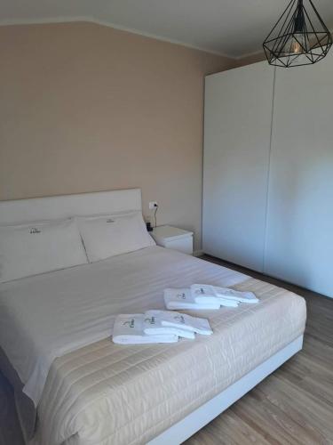 a bedroom with a white bed with two towels on it at Il limone in Gargnano