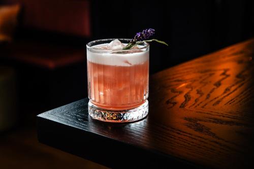 a drink sitting on a table with a flower in it at Harkham Lodge in Pokolbin