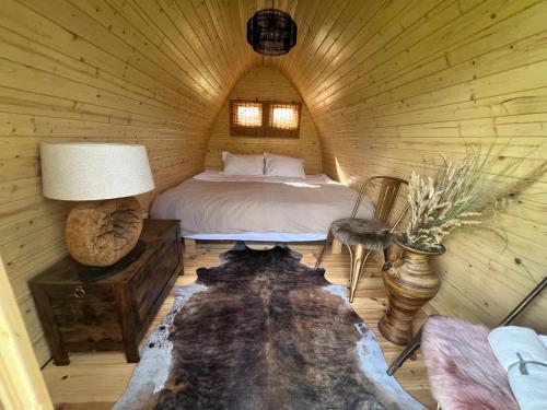 a bedroom with a bed in a log cabin at Dragonfly Glamping Spa Retreat in Ashford