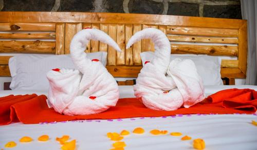 two pink towels sitting on top of a bed at Naivasha Peppercorn Holiday Resort in Naivasha