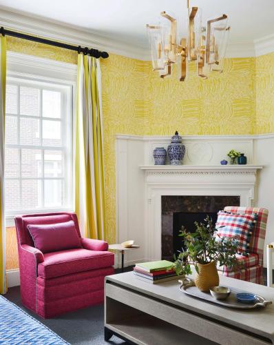 a living room with a pink chair and a fireplace at Graduate by Hilton Columbia SC in Columbia