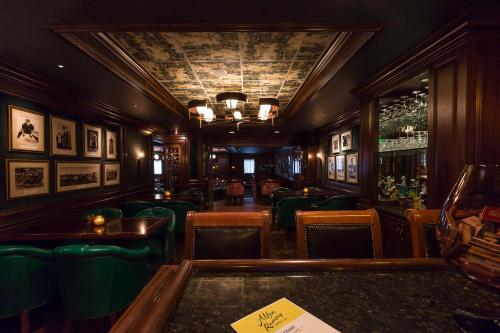 a restaurant with green chairs and a bar at Graduate by Hilton Ann Arbor in Ann Arbor