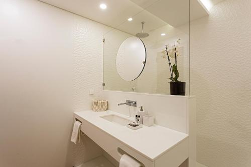 a white bathroom with a sink and a mirror at 54 São Paulo - Exclusive Apartment Hotel in Lisbon