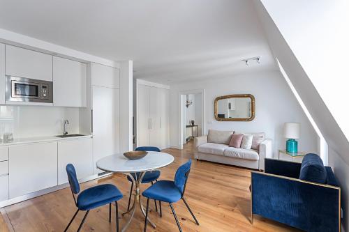 a living room with a table and chairs and a couch at 54 São Paulo - Exclusive Apartment Hotel in Lisbon