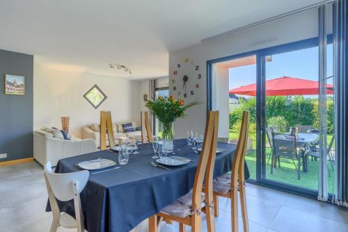 une salle à manger avec une table et un chiffon bleu dans l'établissement Maison Tieghez- Charmante maison à 15min de Vannes, à Ploeren
