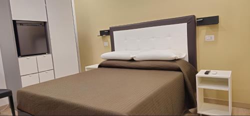 a bed with two pillows on top of it at Convenient Booking B&B in Rome