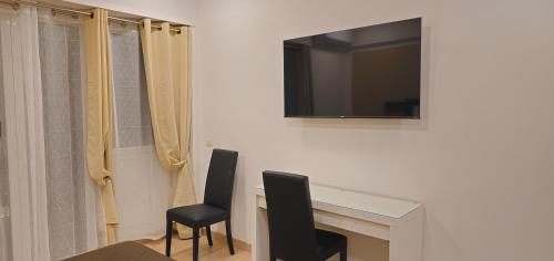 a room with a table and two chairs and a television at Convenient Booking B&B in Rome