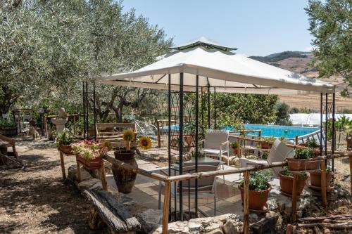 a patio with a white umbrella and a swimming pool at Villa aperta campagna in Nicosia
