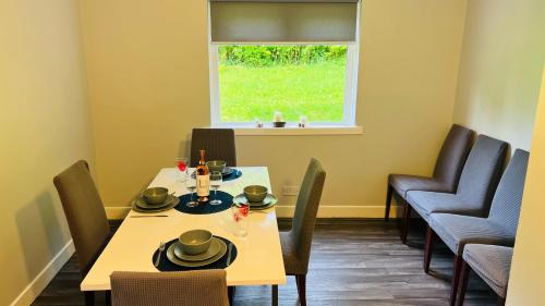 a dining room with a table and chairs and a window at Garnock 3 in Beith