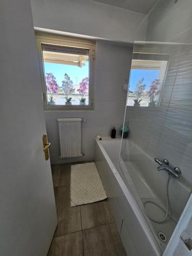 a white bathroom with a tub and a window at Le Duplex in Antibes