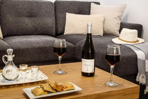 a table with a bottle of wine and two glasses at Nicolas Urban Comfort Living in Souda