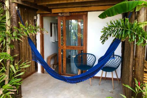 a hammock on the front porch of a house at Pousada Pipe House in Itacaré