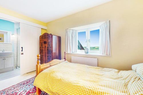 a bedroom with a bed and a window at The Wool Barn Simonsbath in Exford