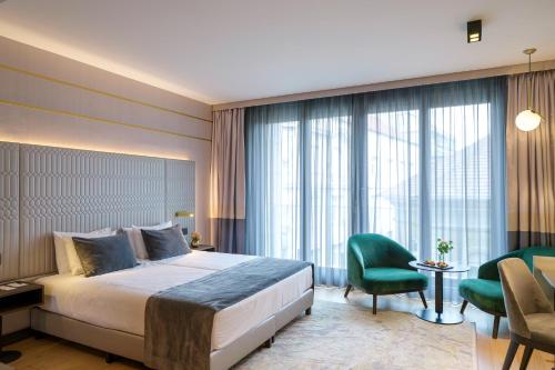 a hotel room with a bed and a desk and chairs at Emerald Downtown Luxury Suites by Continental Group in Budapest