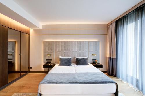 a bedroom with a large bed with blue pillows at Emerald Downtown Luxury Suites by Continental Group in Budapest