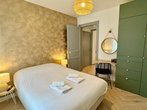 une chambre avec un lit avec deux serviettes dessus dans l'établissement Au Mélo' - Proche Gare & Centre, à Reims