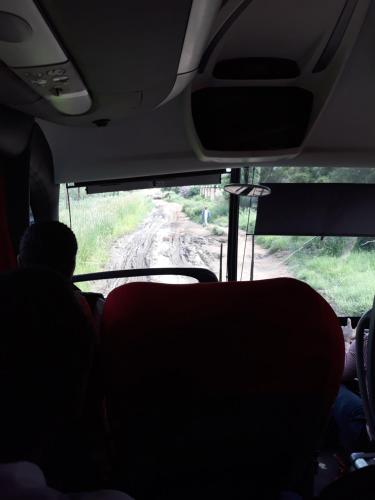 a view of a dirt road from the inside of a bus at The Big Five Lodge in Gaborone