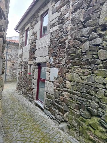 a stone building with a window on a street at Casa do Alambique in Castro Daire