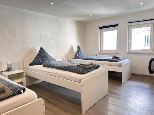 two beds in a room with two windows at Apartment am Markt in Adenau