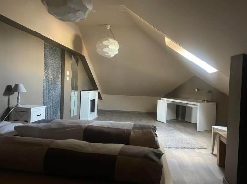 a bedroom with two beds and a desk in a attic at Vakantiewoning Bij de Jep in Bilzen
