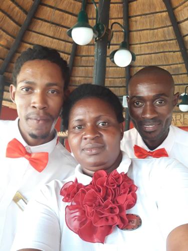 three men in white shirts and red bow ties at The Big Five Lodge in Gaborone