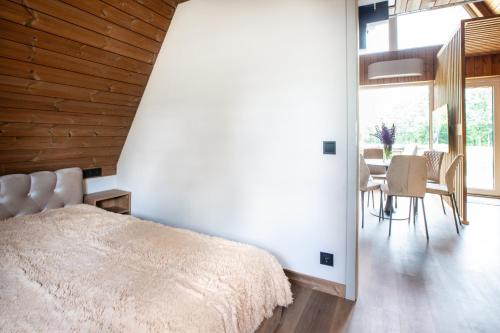 a bedroom with a bed and a table and chairs at Poilsio Vingis in Liūnai