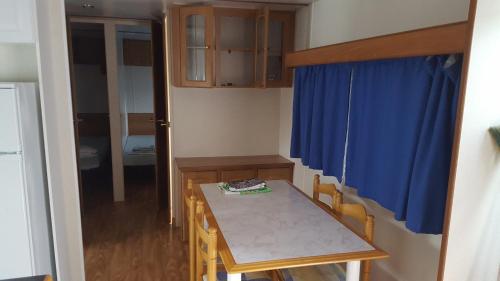a small room with a table and a blue curtain at Bungalows Land'shause in Pataias