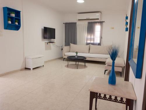 a living room with a couch and a table at Palmera by LOREN VILLAGE in Neve Zohar